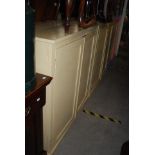 THREE PAINTED PINE TWO DOOR COUNTRY HOUSE CUPBOARDS, TWO CREAM COLOURED, THE OTHER BLUE, PINK AND