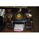 LATE 19TH CENTURY POLISHED SLATE CLOCK GARNITURE COMPRISING MANTEL CLOCK AND PAIR OF COMPANION BUSTS