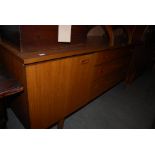 A MID 20TH CENTURY TEAK SIDEBOARD WITH THREE CENTRAL DRAWERS FLANKED BY CUPBOARD DOORS TOGETHER WITH