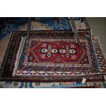 THREE ASSORTED PERSIAN RUGS TO INCLUDE MADDER GROUND RUG CENTRED WITH DOUBLE MEDALLION SLIGHTLY