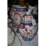 A MATCHED JAPANESE IMARI GARNITURE, COMPRISING A LIDDED URN AND TWO BALUSTER VASES