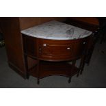 AN EARLY 20TH CENTURY MAHOGANY AND MARBLE CIRCULAR CORNER UNIT WITH A SINGLE DOOR CUPBOARD ON