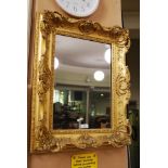 A GILT WOOD PICTURE FRAME ENCLOSING A MIRROR PLATE