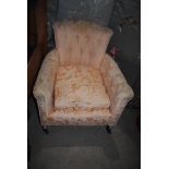 AN EARLY 20TH CENTURY STUDDED UPHOLSTERED ARMCHAIR IN PEACH BROCADE STYLE FABRIC WITH STUDDED ARMS