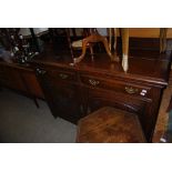 A 20TH CENTURY OAK SIDEBOARD WITH TWO LONG DRAWERS OVER A DOUBLE DOOR CUPBOARD
