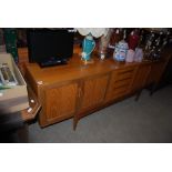 A MID 20TH CENTURY G-PLAN TEAK SIDEBOARD WITH FOUR SHORT DRAWERS FLANKED BY A PAIR OF DOUBLE