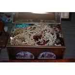 A CASKET CONTAINING A LARGE COLLECTION OF ASSORTED COSTUME JEWELLERY, NECKLACES