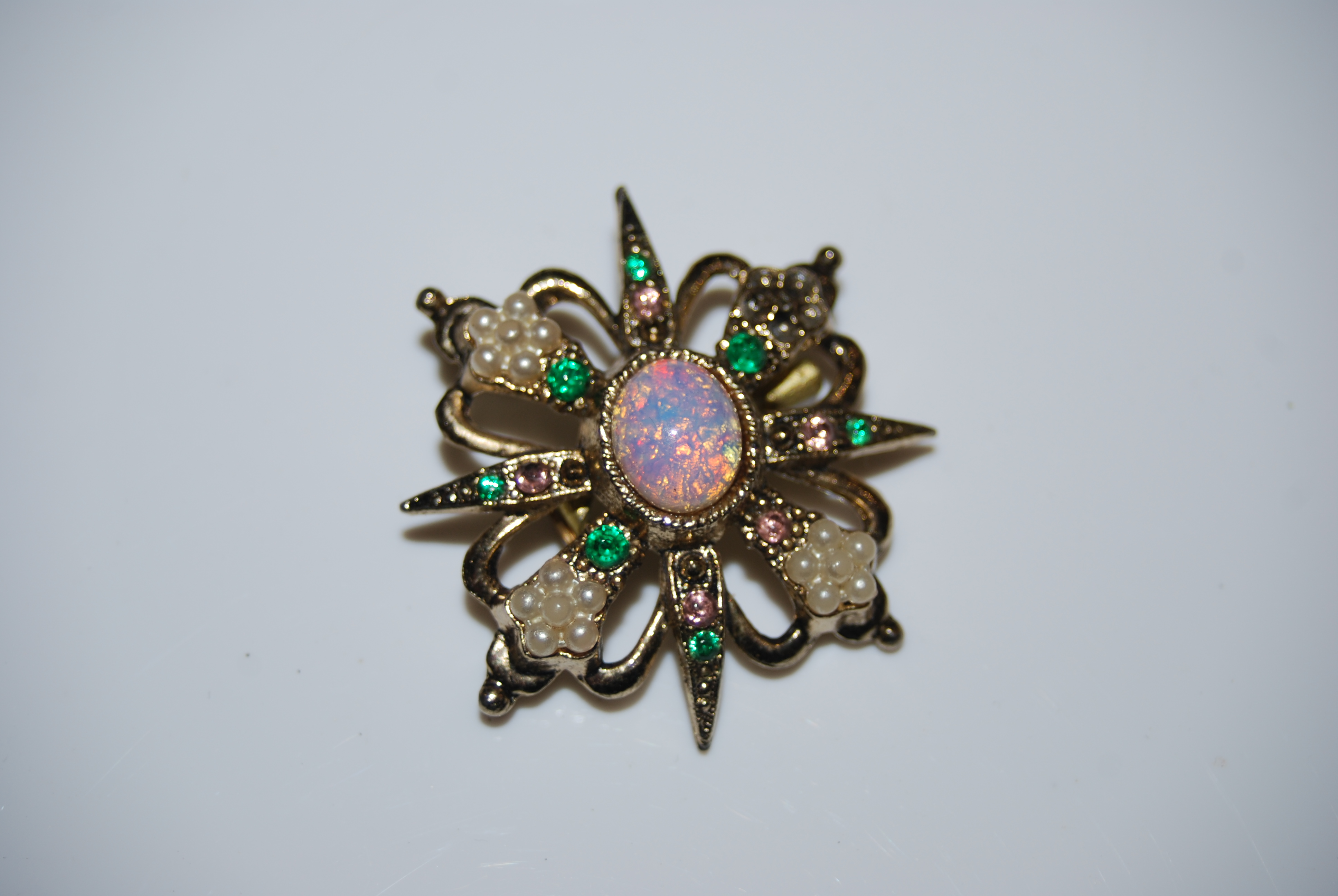 A COSTUME JEWELLERY BROOCH CENTRED WITH OVAL CABOUCHON OPAL