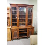 A VICTORIAN OAK BOOKCASE WITH GLAZED UPPER SECTION ON A BASE WITH CENTRAL OPEN RECESSES FLANKED BY