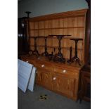 A 20TH CENTURY PINE DRESSER WITH THREE TIER OPEN PLATE RACK, THREE FRIEZE DRAWERS ABOVE THREE