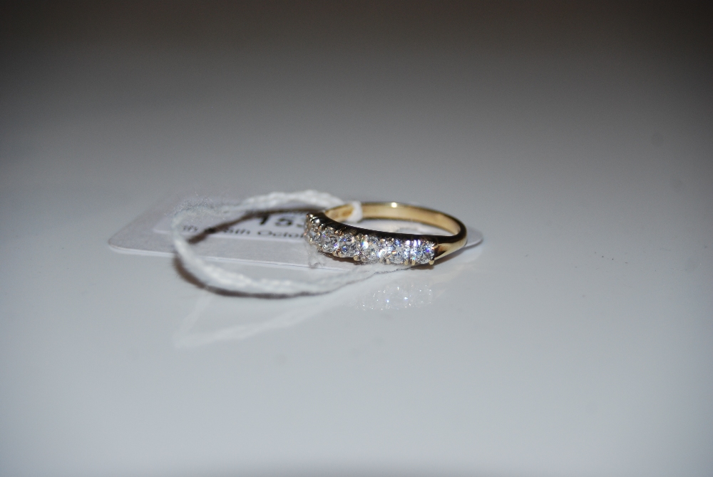 A 9CT GOLD AND CUBIC ZIRCONIA SEVEN STONE RING