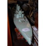 A WOODEN MODEL OF A 20TH CENTURY BATTLESHIP ON STAND