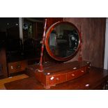 AN EARLY 20TH CENTURY MAHOGANY TABLE MIRROR, THE OVAL MIRROR SUPPORTED BY TWO TURNED SUPPORTS ON A