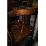 A 20TH CENTURY PALE MAHOGANY OCCASIONAL TABLE OF DRUM FORM ON A SINGLE TURNED SUPPORT OVER THREE PAW