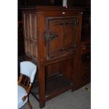 AN EARLY 20TH CENTURY ARTS AND CRAFTS STYLE CUPBOARD WITH CENTRAL LEAD MOUNTED GLASS DOOR WITH