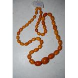 A STRING OF GRADUATED BUTTERSCOTCH AMBER BEADS, GROSS WEIGHT 97.5 GRAMS