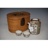 CHINESE PORCELAIN FAMILLE ROSE CANTON TEA KETTLE, COVER AND TWO TEA BOWLS IN ORIGINAL WICKER CASE.