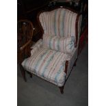 A MODERN MAHOGANY WINGBACK UPHOLSTERED IN STRIPED BROCADE STYLE FABRIC