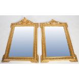 A pair of Victorian gilt gesso wall mirrors, of rectangular form with moulding scrolling crests with
