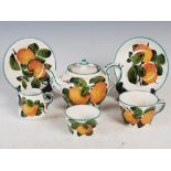 A Wemyss Pottery tea set for one, decorated with oranges, comprising; teapot and cover, milk jug,