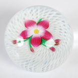 A Perthshire Paperweight, decorated with a pink and white five petal flower on a latticino ground,
