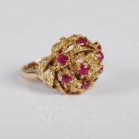 A 9ct gold and ruby cocktail ring, circa 1970's, set with 8 round faceted rubies, ring size M.