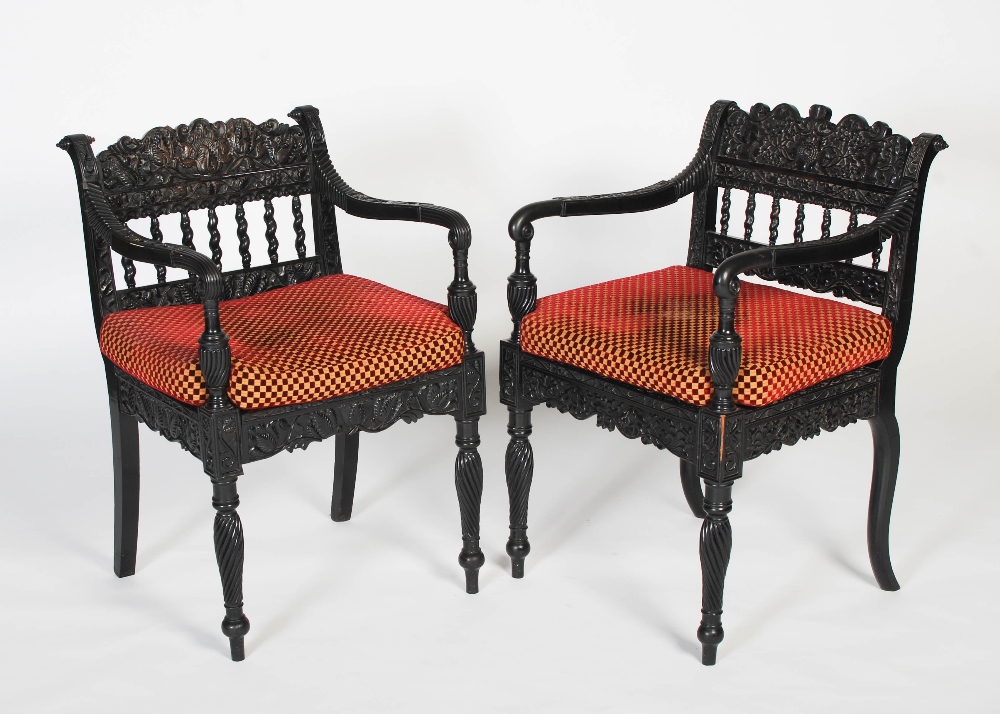 A pair of matched Anglo-Indian ebony armchairs, mid 19th century, possibly Ceylonese, the frames