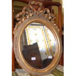 Oval gilt framed mirror, the top from with bow pediment, 51cm high.