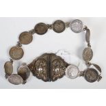 White metal mounted Burmese coin set belt, with two-part buckle bearing embossed decoration of