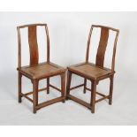 A pair of Chinese blond wood yokeback armchairs, Qing Dynasty, each with a curved crest rail