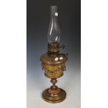 Late 19th/ early 20th century brass oil lamp, with glass flume on a urn style base with putti