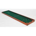 An early 20th century mahogany bagatelle game, a two-part fold out case lined in green felt with