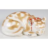 Japanese Kutani porcelain figure of a recumbent cat, late 19th/ early 20th century, 26cm wide.