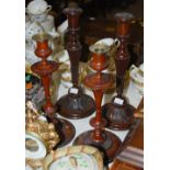 Two pairs of mahogany candlesticks, including a turned and fluted pair with gadrooned rim and carved