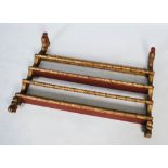 An unusual 19th century giltwood wall mounted plate rack, formed of two serpentine supports carved