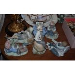 Six Lladro figures of children, including figures of boys with dogs, a girl clutching a bouquet of