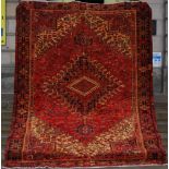 A Persian Heriz rug, the red field with angular vine together with various hooked floral motifs