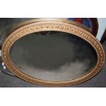 Early 20th century gilt gesso oval mirror, the border with repeating design of acorns and oak