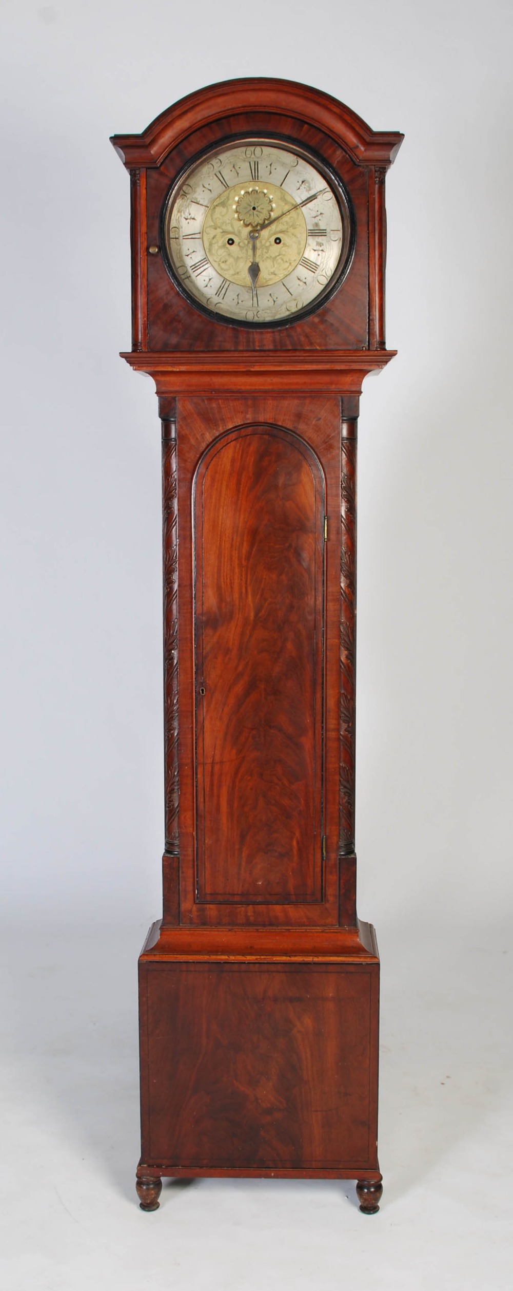 A late 18th century mahogany longcase clock, the arched hood flanked by quarter columns, the trunk