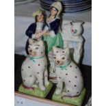 Pair of late 19th century Staffordshire cat figures, the cats with green bows and puce spots,