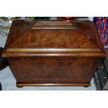 A 19th century walnut tea caddy of sarcophagus shape, with panelled dome lid, the panels cross-