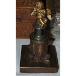 Late 19th/ early 20th century bronze and brass figure of Cupid, on top of a upturned capital base on