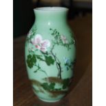 Chinese porcelain celadon ground vase, with enamel decoration of flowers and foliage.