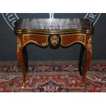 A 19th Century Boulle games table, the hinged serpentine top opening to a green baize lined interior