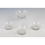 A set of four Lalique clear and green stained fruit bowls, the straight sided feet moulded with