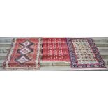 Group of three rugs, to include a madder ground tekke rug, the rectangular field with three rows
