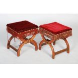 A pair of Victorian Gothic Revival oak footstools, the square padded tops upholstered in red