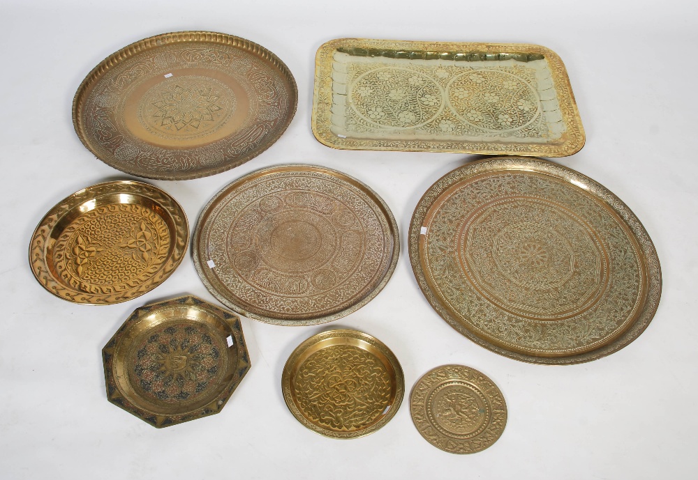 Seven large brass trays, including Middle Eastern and Indian examples, most with embossed designs,