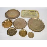Seven large brass trays, including Middle Eastern and Indian examples, most with embossed designs,