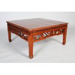 A 20th century Chinese carved wood coffee table, the plank top with frieze carved and pieced with